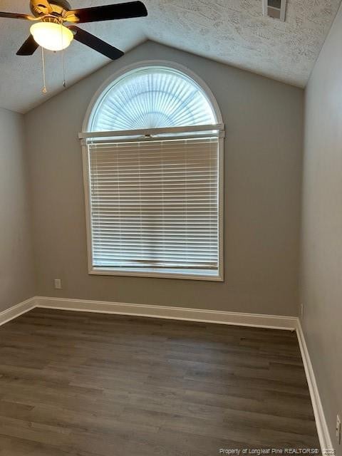 unfurnished room with ceiling fan, dark hardwood / wood-style floors, a textured ceiling, and vaulted ceiling