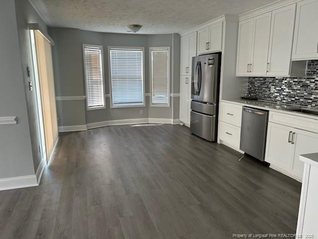 kitchen with decorative backsplash, stainless steel appliances, dark wood-type flooring, sink, and white cabinets