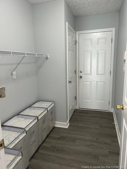 laundry room featuring washer and dryer, dark hardwood / wood-style floors, and a textured ceiling