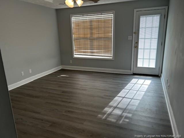 empty room featuring ceiling fan and dark hardwood / wood-style floors