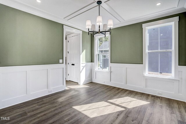 unfurnished dining area with a notable chandelier, hardwood / wood-style flooring, and ornamental molding