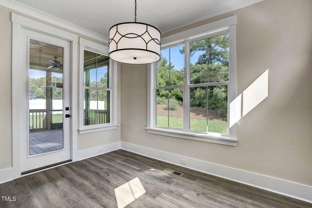 unfurnished dining area with ornamental molding and hardwood / wood-style floors