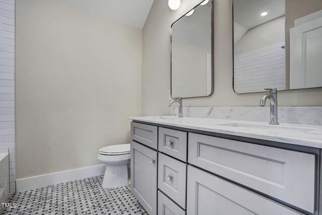 bathroom featuring tile patterned flooring, vanity, and toilet