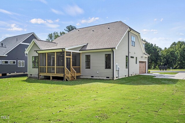 rear view of house featuring a garage, a sunroom, and a yard