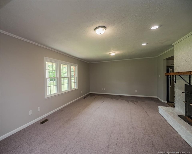 unfurnished living room featuring a fireplace, a textured ceiling, carpet floors, and ornamental molding