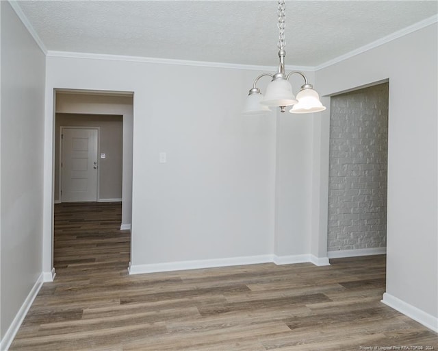 unfurnished dining area with a textured ceiling, a notable chandelier, crown molding, and dark wood-type flooring