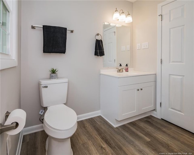 bathroom with toilet, vanity, and hardwood / wood-style flooring