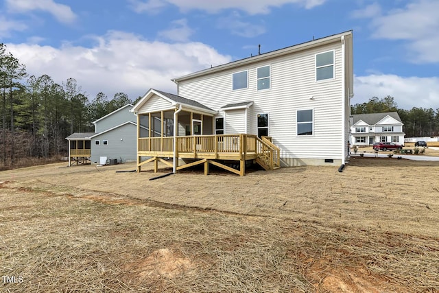 rear view of house featuring a wooden deck and a sunroom