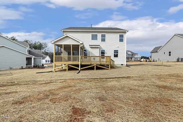 rear view of house featuring a wooden deck and a sunroom