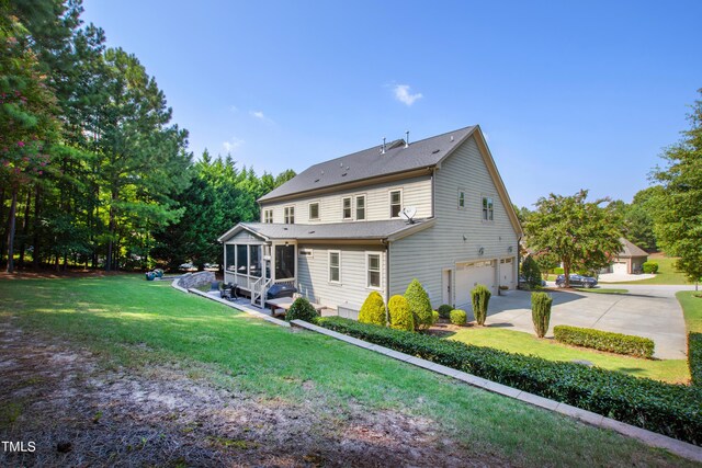 3209 Bryant Falls Ct, Raleigh, NC 27613 - rear view of house featuring an attached garage, concrete driveway, a sunroom, a lawn, and roof with shingles