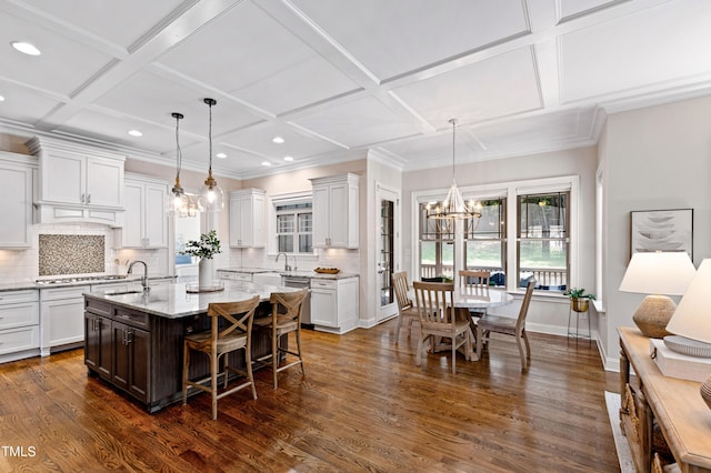 3209 Bryant Falls Ct, Raleigh, NC 27613 - kitchen featuring coffered ceiling, backsplash, a center island with sink, white cabinets, and light stone countertops