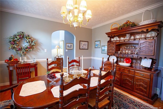 dining space with ornamental molding, a textured ceiling, and a notable chandelier