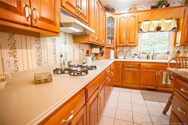 kitchen featuring tasteful backsplash, sink, white gas stovetop, and light tile patterned flooring