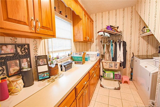 washroom with cabinets, light tile patterned flooring, separate washer and dryer, and a textured ceiling