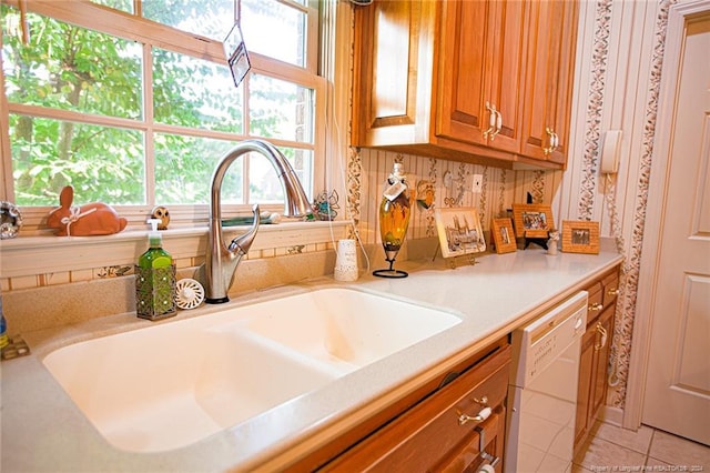 kitchen with dishwasher, sink, and light tile patterned floors