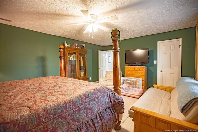 bedroom with ceiling fan, carpet floors, and a textured ceiling