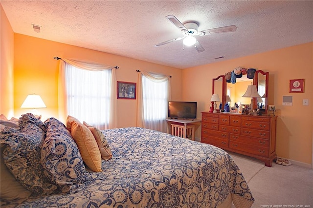 bedroom with light carpet, a textured ceiling, and ceiling fan