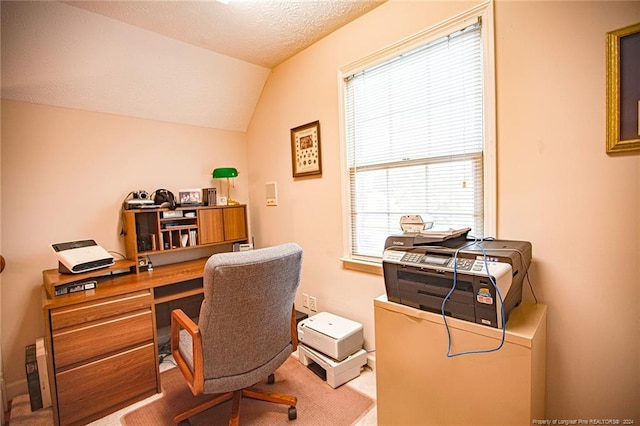 carpeted home office featuring vaulted ceiling and a textured ceiling