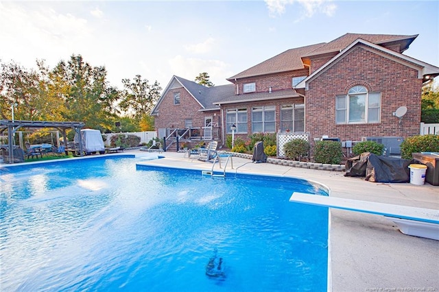 view of pool featuring a patio, a pergola, and a diving board