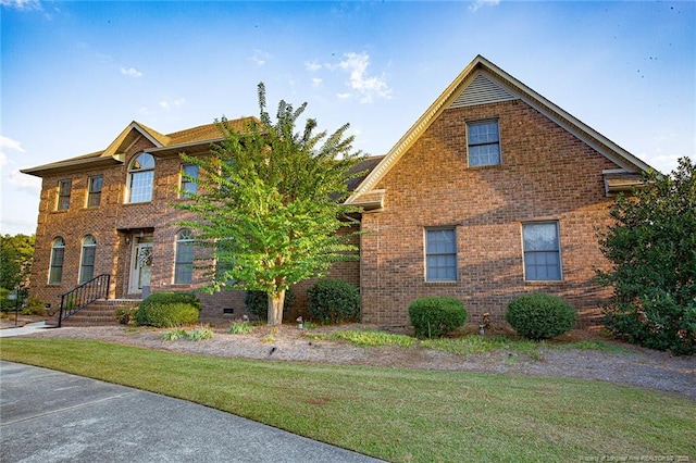 view of front of house featuring a front yard and brick siding