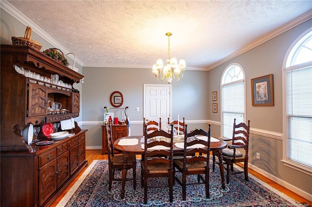 dining area with a chandelier, light wood-style floors, and crown molding