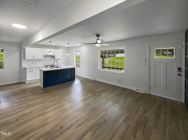 unfurnished living room featuring ceiling fan, dark hardwood / wood-style flooring, and sink