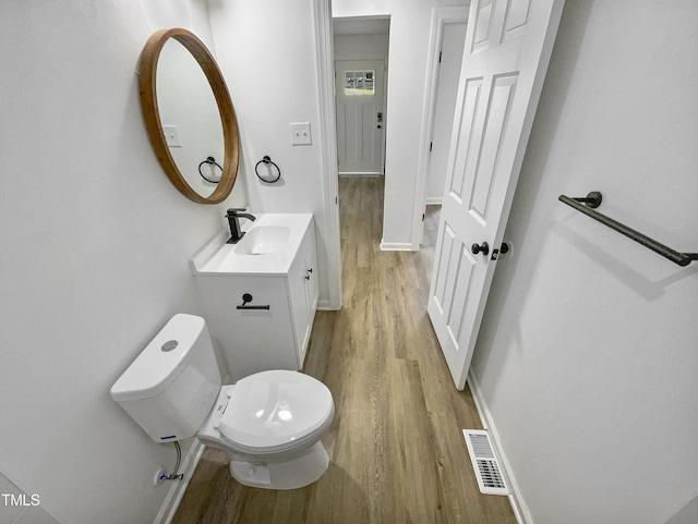 bathroom with hardwood / wood-style floors, vanity, and toilet