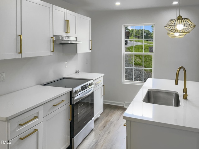 kitchen featuring white cabinetry, sink, light hardwood / wood-style flooring, decorative light fixtures, and stainless steel range with electric cooktop