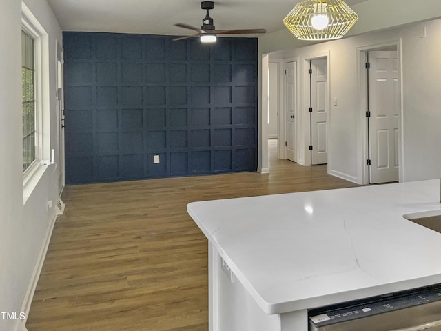 interior space with dishwasher, wood-type flooring, ceiling fan, and pendant lighting