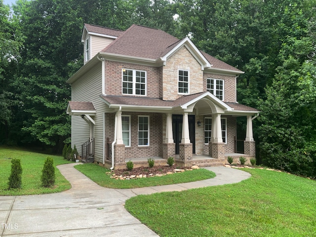 craftsman inspired home featuring covered porch and a front lawn