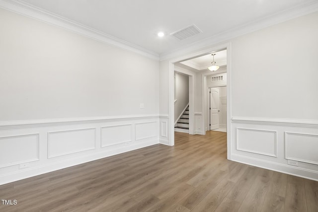 empty room with wood-type flooring and ornamental molding