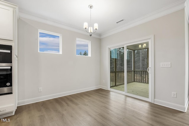 unfurnished room with crown molding, an inviting chandelier, and light hardwood / wood-style flooring