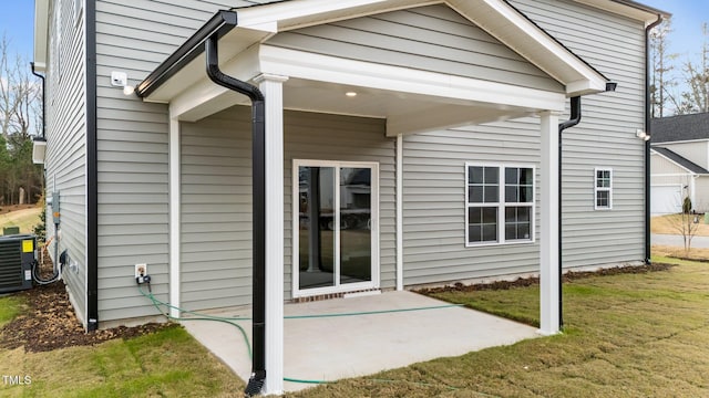 back of property featuring central AC unit, a yard, and a patio