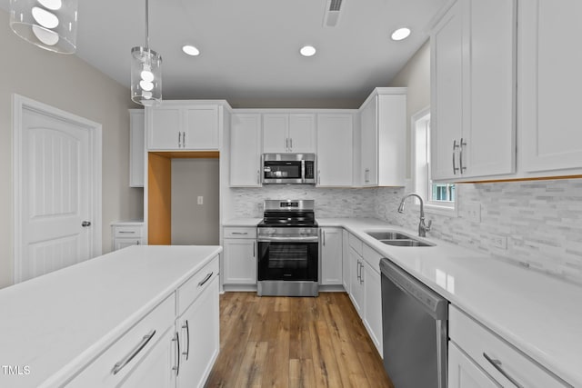 535 Husketh Rd, Youngsville, NC 27596 - kitchen featuring appliances with stainless steel finishes, white cabinetry, light countertops, wood finished floors, and recessed lighting
