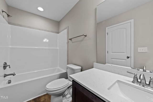 full bathroom with washtub / shower combination, vanity, hardwood / wood-style flooring, and toilet