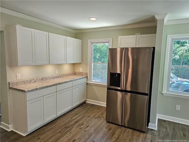 kitchen featuring light stone counters, ornamental molding, dark wood-type flooring, stainless steel fridge with ice dispenser, and white cabinetry