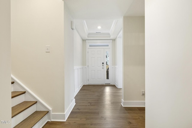 foyer entrance featuring dark wood-type flooring and crown molding