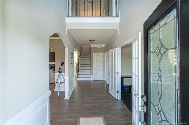 entryway with dark hardwood / wood-style floors, ornamental molding, and french doors