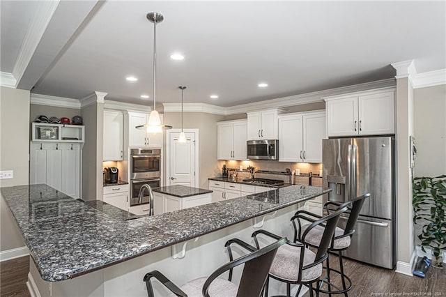 kitchen with hanging light fixtures, a center island, stainless steel appliances, and white cabinetry