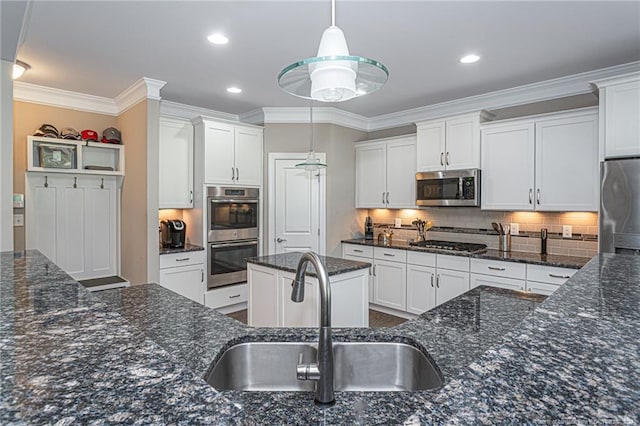 kitchen with decorative light fixtures, sink, white cabinetry, and appliances with stainless steel finishes