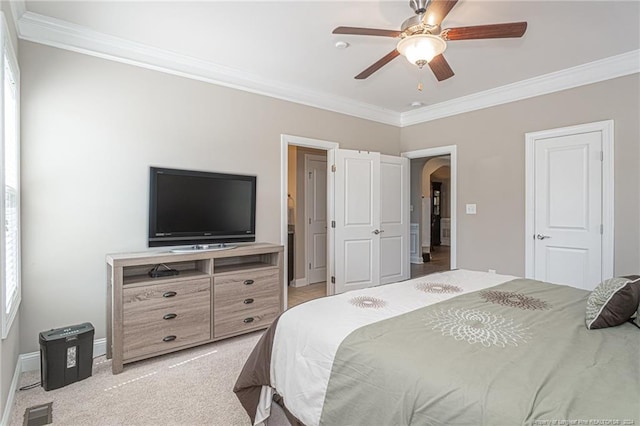 carpeted bedroom with ceiling fan and ornamental molding