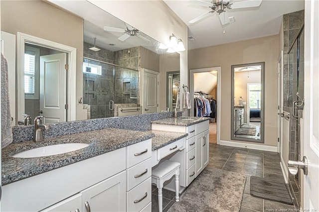 bathroom with ceiling fan, plenty of natural light, walk in shower, and vanity