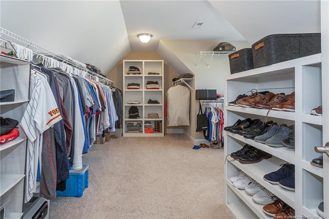 walk in closet featuring light colored carpet and lofted ceiling