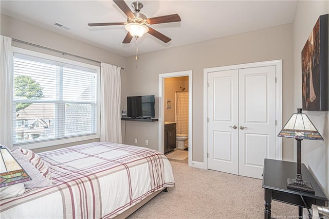 carpeted bedroom with ceiling fan, ensuite bathroom, and a closet