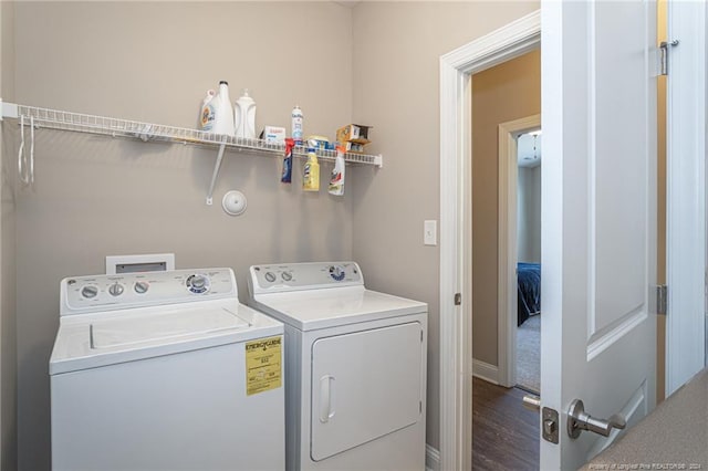 washroom featuring washing machine and dryer and dark wood-type flooring