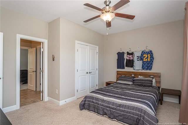 bedroom with ceiling fan, light carpet, and a closet