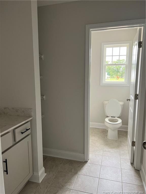 bathroom with tile patterned flooring, vanity, and toilet