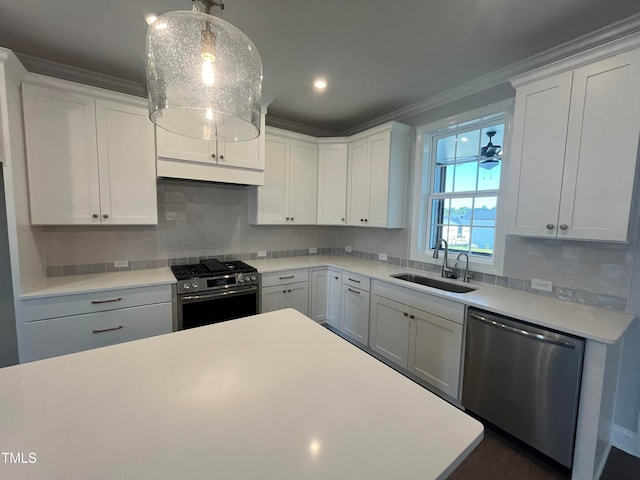 kitchen featuring appliances with stainless steel finishes, decorative light fixtures, white cabinetry, and sink