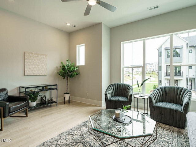 living room with ceiling fan and light hardwood / wood-style flooring