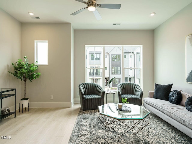 living room featuring ceiling fan and light hardwood / wood-style floors